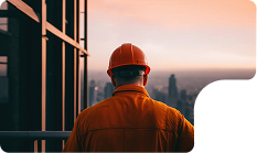 Worker in orange overalls looking out over a city skyline
